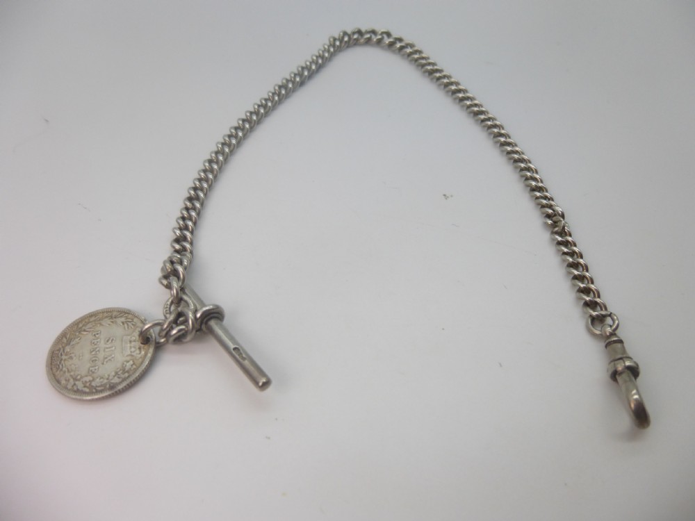 A sterling silver Albert pocket watch chain featuring curb links, a T-bar, a swivel clasp, and an attached silver coin fob against a plain background. View II