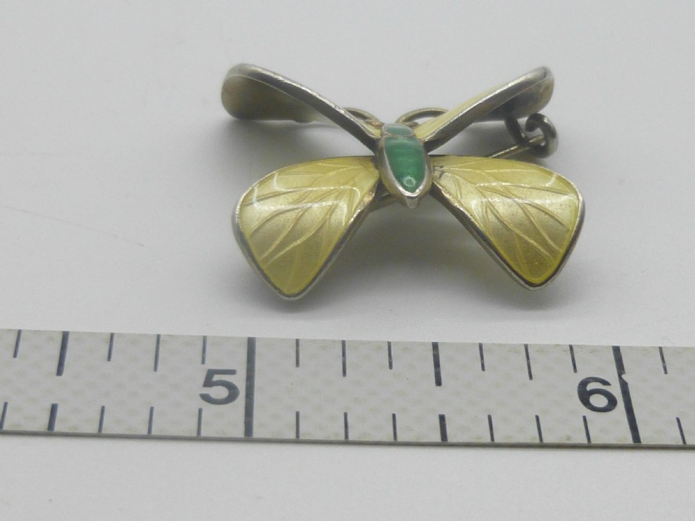 A silver butterfly brooch featuring yellow guilloche enamel wings, a green enamelled body, and red accent eyes. View II