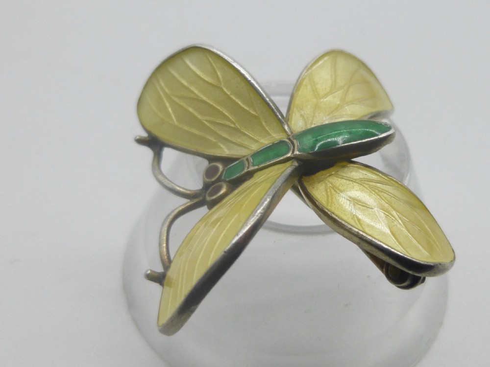 A silver butterfly brooch featuring yellow guilloche enamel wings, a green enamelled body, and red accent eyes. View III