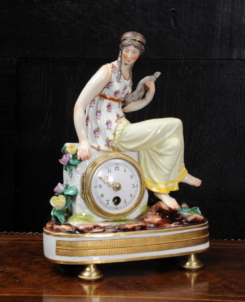 fig 1. A late 19th-century Vienna porcelain clock featuring a hand-painted seated female figure atop a gilded metal base.