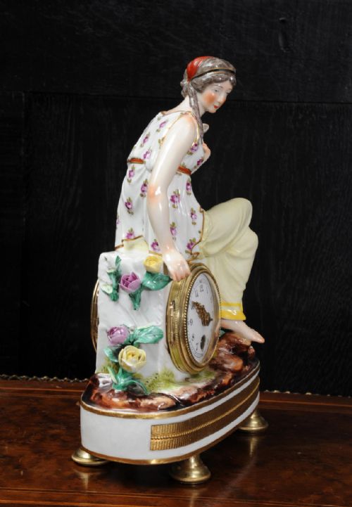 fig 2. A late 19th-century Vienna porcelain clock featuring a hand-painted seated female figure atop a gilded metal base.