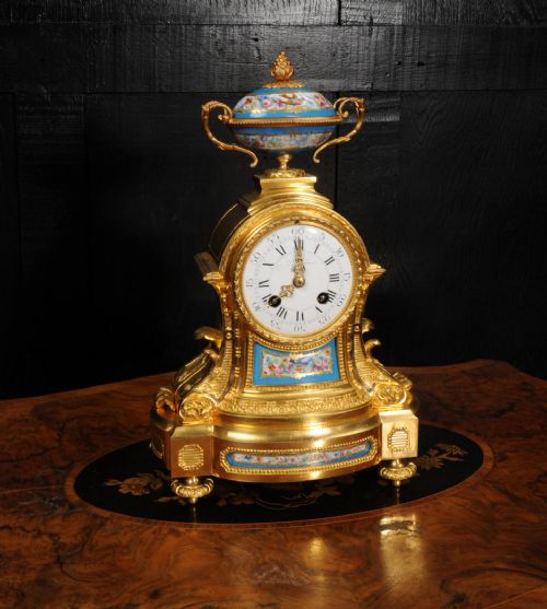 fig 3. An antique French ormolu mantel clock featuring hand-painted turquoise porcelain panels and a porcelain urn finial atop a gilded bronze case.