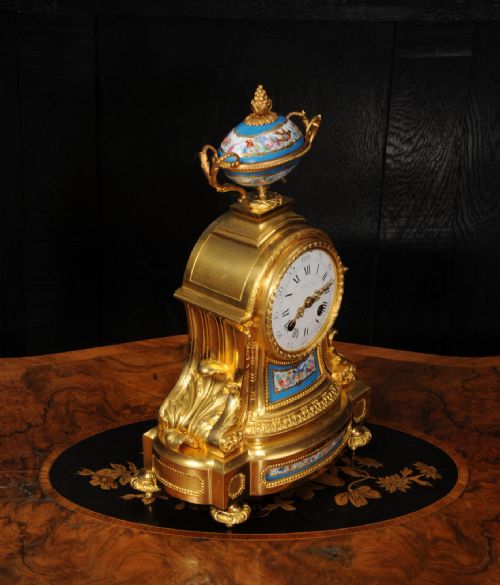 fig 5. An antique French ormolu mantel clock featuring hand-painted turquoise porcelain panels and a porcelain urn finial atop a gilded bronze case.