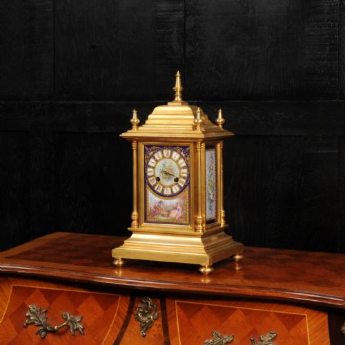 fig 2. An antique gilt bronze mantel clock featuring hand-painted floral and figure porcelain panels, corner columns, and decorative top finials.