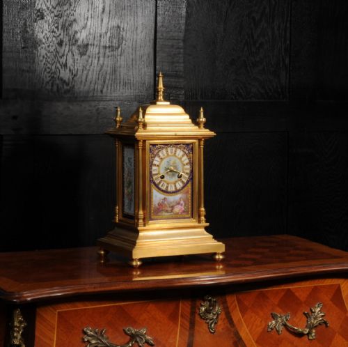 fig 4. An antique gilt bronze mantel clock featuring hand-painted floral and figure porcelain panels, corner columns, and decorative top finials.
