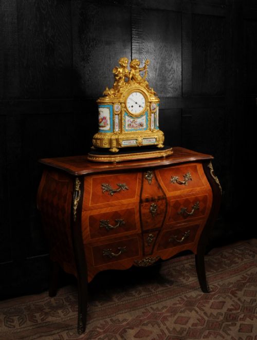 fig 8. A French gilt bronze and celeste blue porcelain mantel clock topped with two gilded cherub figures and hand-painted floral panels surrounding a white enamel dial.