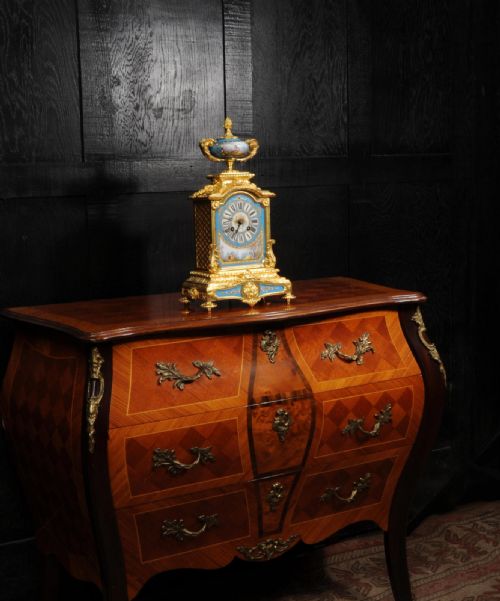 fig 3. An antique French ormolu mantel clock featuring ornate gilt scrollwork, a hand-painted celeste blue porcelain dial, and a matching porcelain urn finial.
