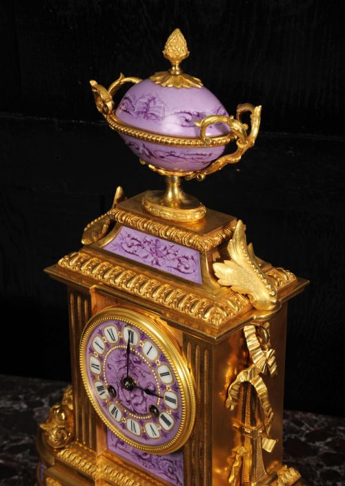 fig 9. An ornate French gilt bronze and lilac hand-painted porcelain mantel clock featuring a decorative urn finial and fluted side columns.