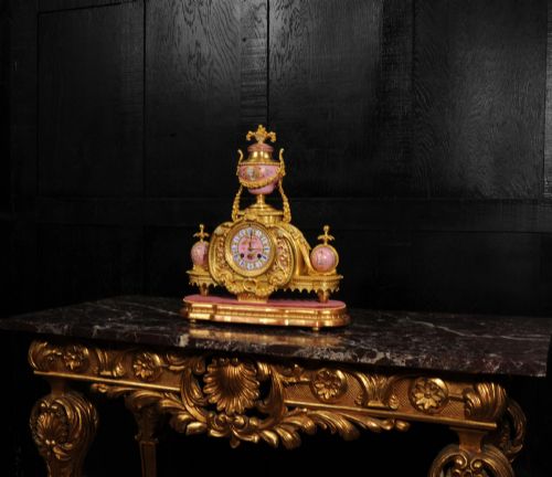 fig 2. An ornate 19th-century French gilt-bronze and pink Sevres porcelain mantel clock featuring scrolled ormolu mounts and hand-painted cherubs.