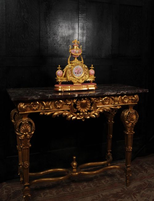 fig 3. An ornate 19th-century French gilt-bronze and pink Sevres porcelain mantel clock featuring scrolled ormolu mounts and hand-painted cherubs.