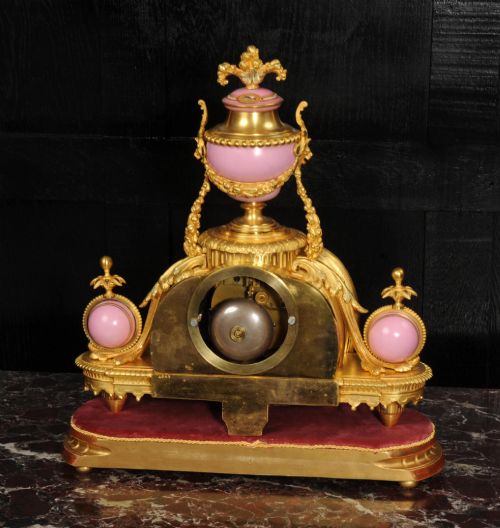 fig 7. An ornate 19th-century French gilt-bronze and pink Sevres porcelain mantel clock featuring scrolled ormolu mounts and hand-painted cherubs.