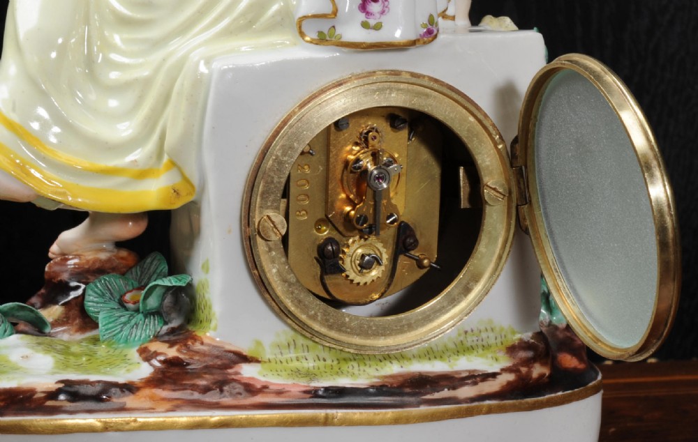 A late 19th-century Vienna porcelain clock featuring a hand-painted seated female figure atop a gilded metal base. View X
