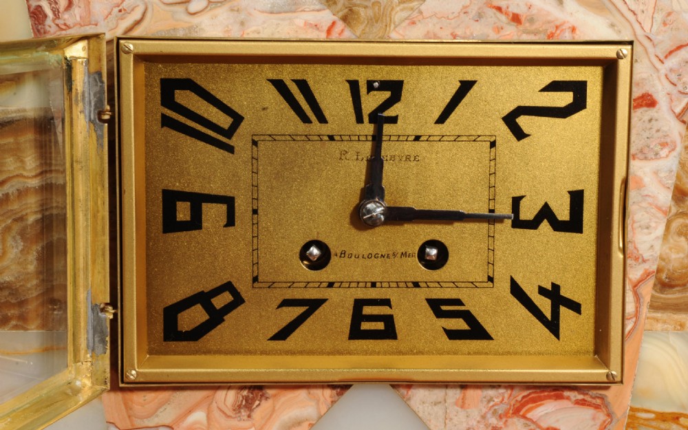 A French Art Deco mantel clock set featuring stepped geometric marble and onyx bases, a square clock face with Arabic numerals, and a seated gilded greyhound sculpture atop the main clock. View XIII