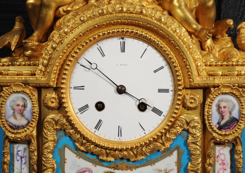 A French gilt bronze and celeste blue porcelain mantel clock topped with two gilded cherub figures and hand-painted floral panels surrounding a white enamel dial. View XVIII