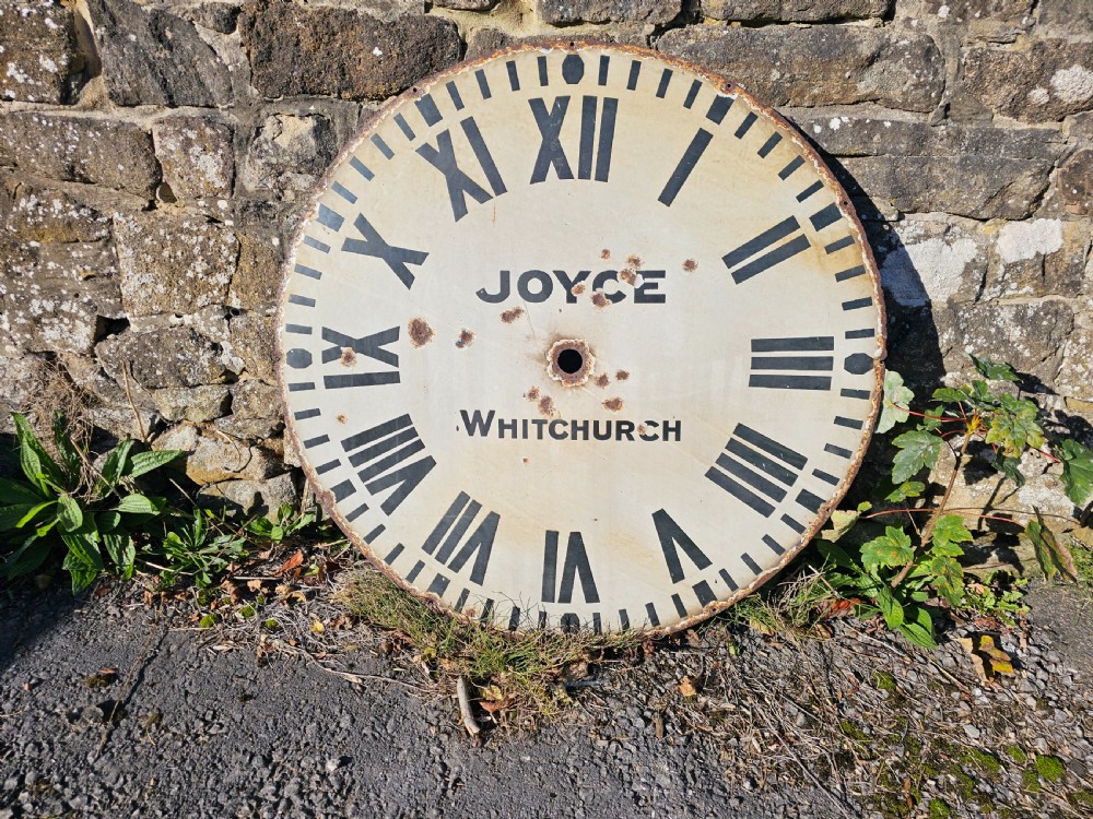 A large circular off-white enamelled turret clock dial featuring black Roman numerals and the maker name Joyce Whitchurch.