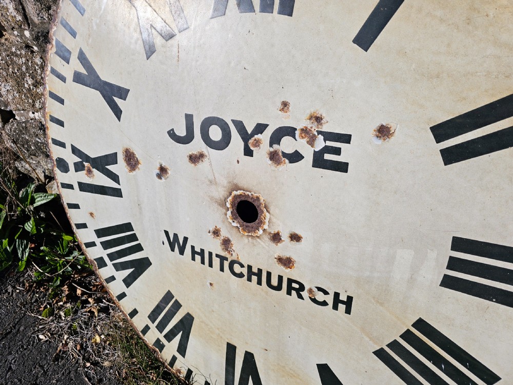 A large circular off-white enamelled turret clock dial featuring black Roman numerals and the maker name Joyce Whitchurch. View IV