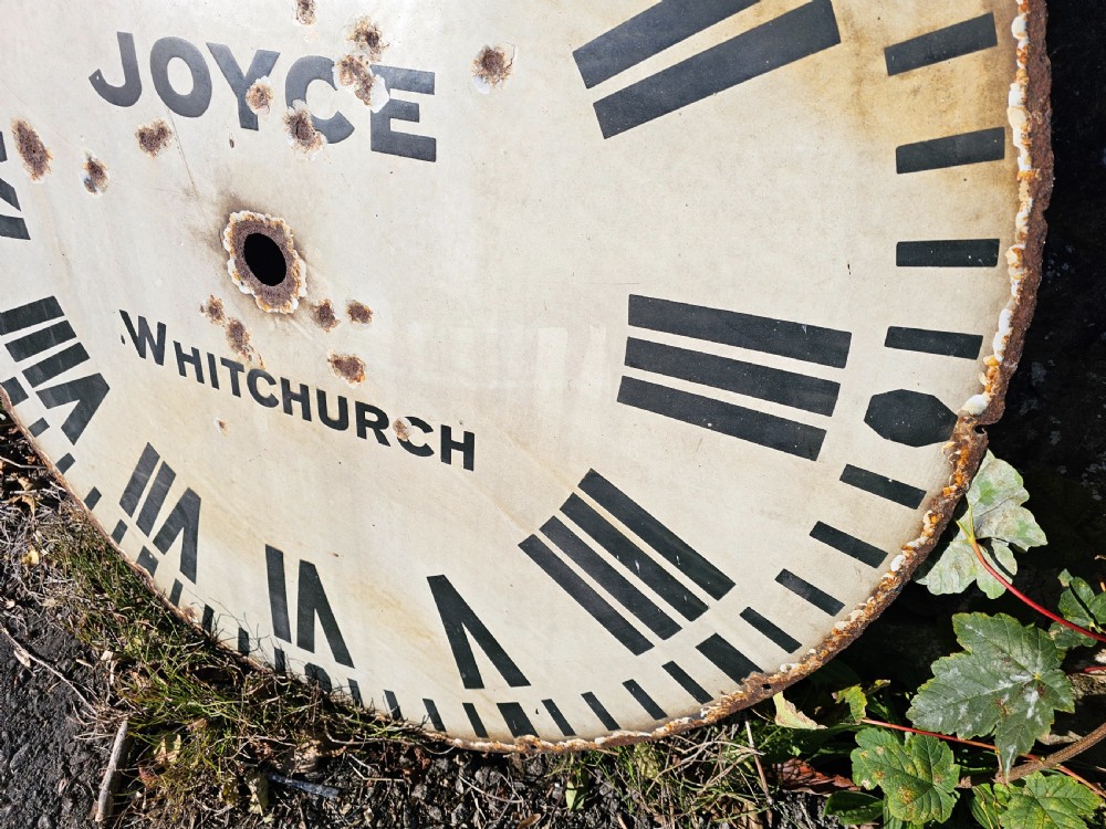 A large circular off-white enamelled turret clock dial featuring black Roman numerals and the maker name Joyce Whitchurch. View VII