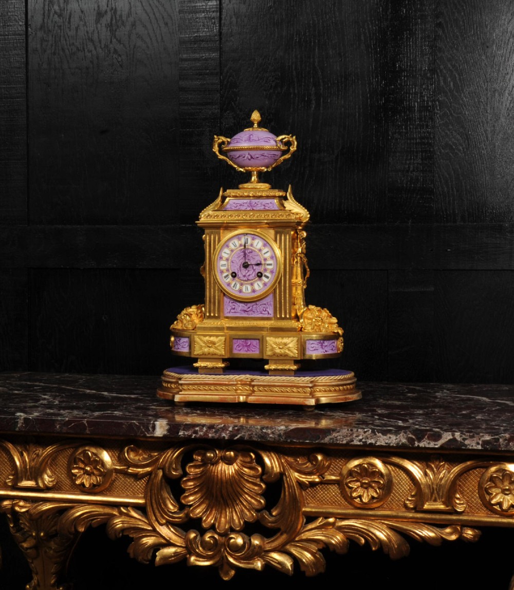 An ornate French gilt bronze and lilac hand-painted porcelain mantel clock featuring a decorative urn finial and fluted side columns. View III
