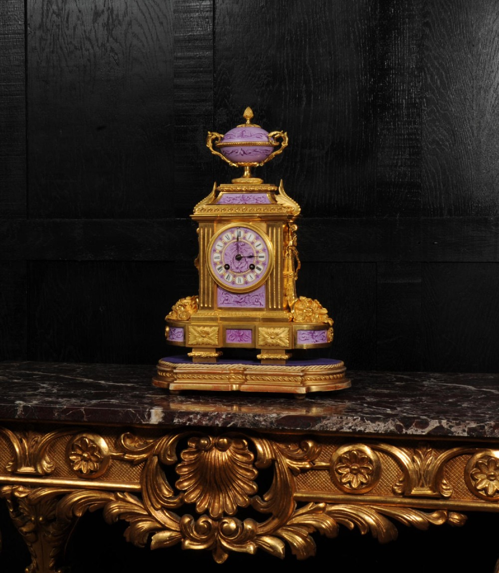 An ornate French gilt bronze and lilac hand-painted porcelain mantel clock featuring a decorative urn finial and fluted side columns. View XI