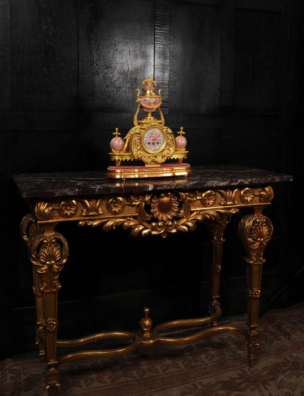 An ornate 19th-century French gilt-bronze and pink Sevres porcelain mantel clock featuring scrolled ormolu mounts and hand-painted cherubs. View IV