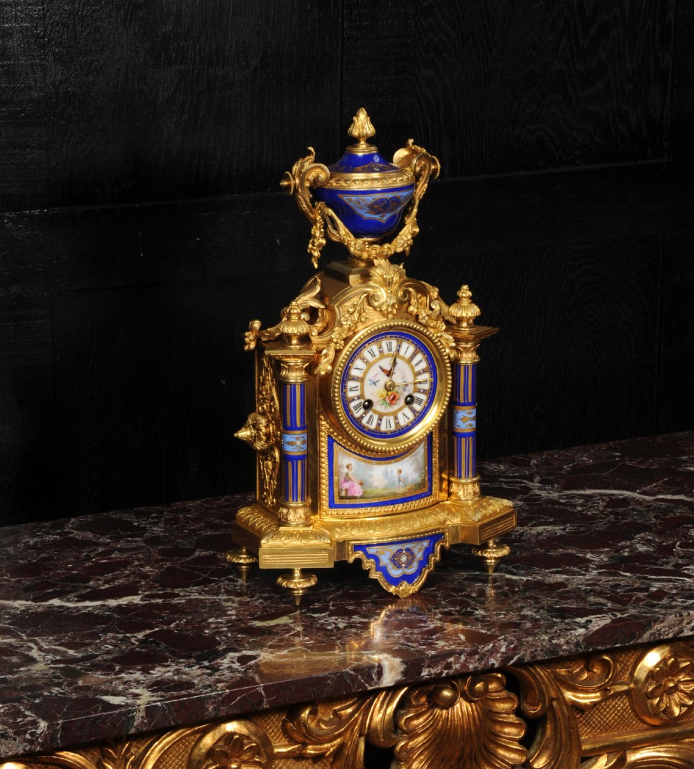 A Louis XVI style French ormolu and cobalt blue hand-painted porcelain mantel clock topped with an urn finial. View X