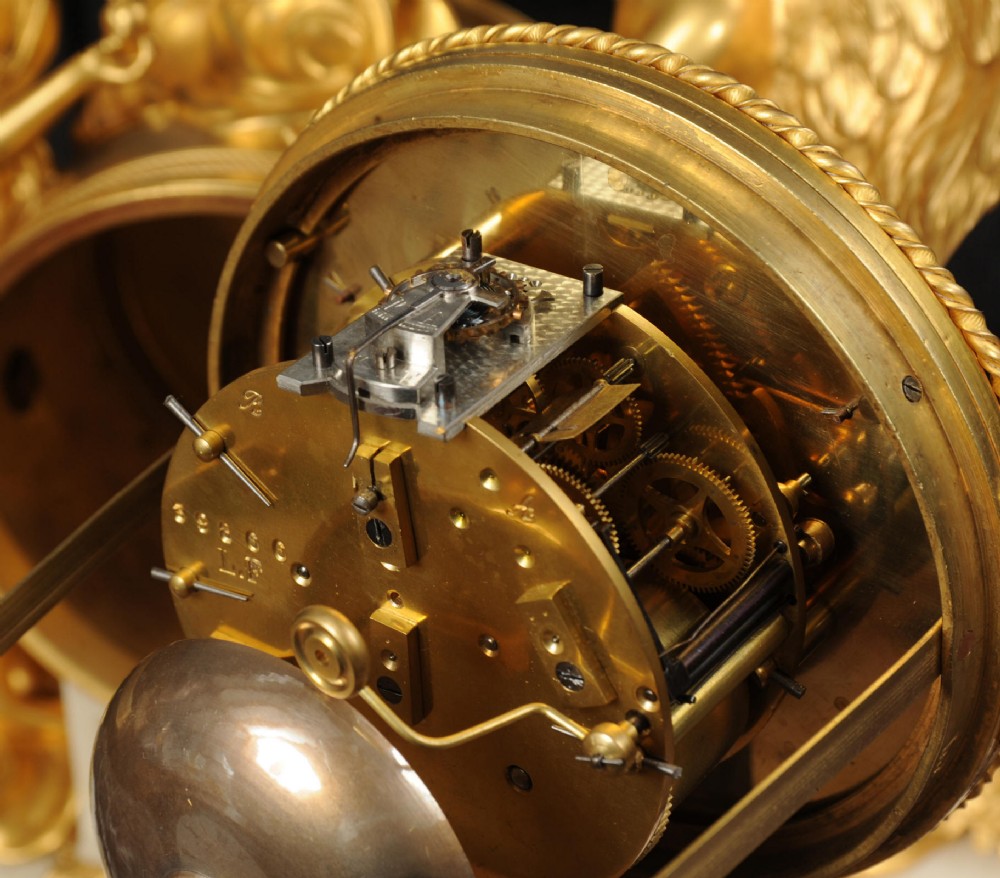 An antique French ormolu and white marble mantel clock featuring gilt bronze figures of Cupid and Psyche surrounding a central white enamel dial on a rectangular marble base. View XII