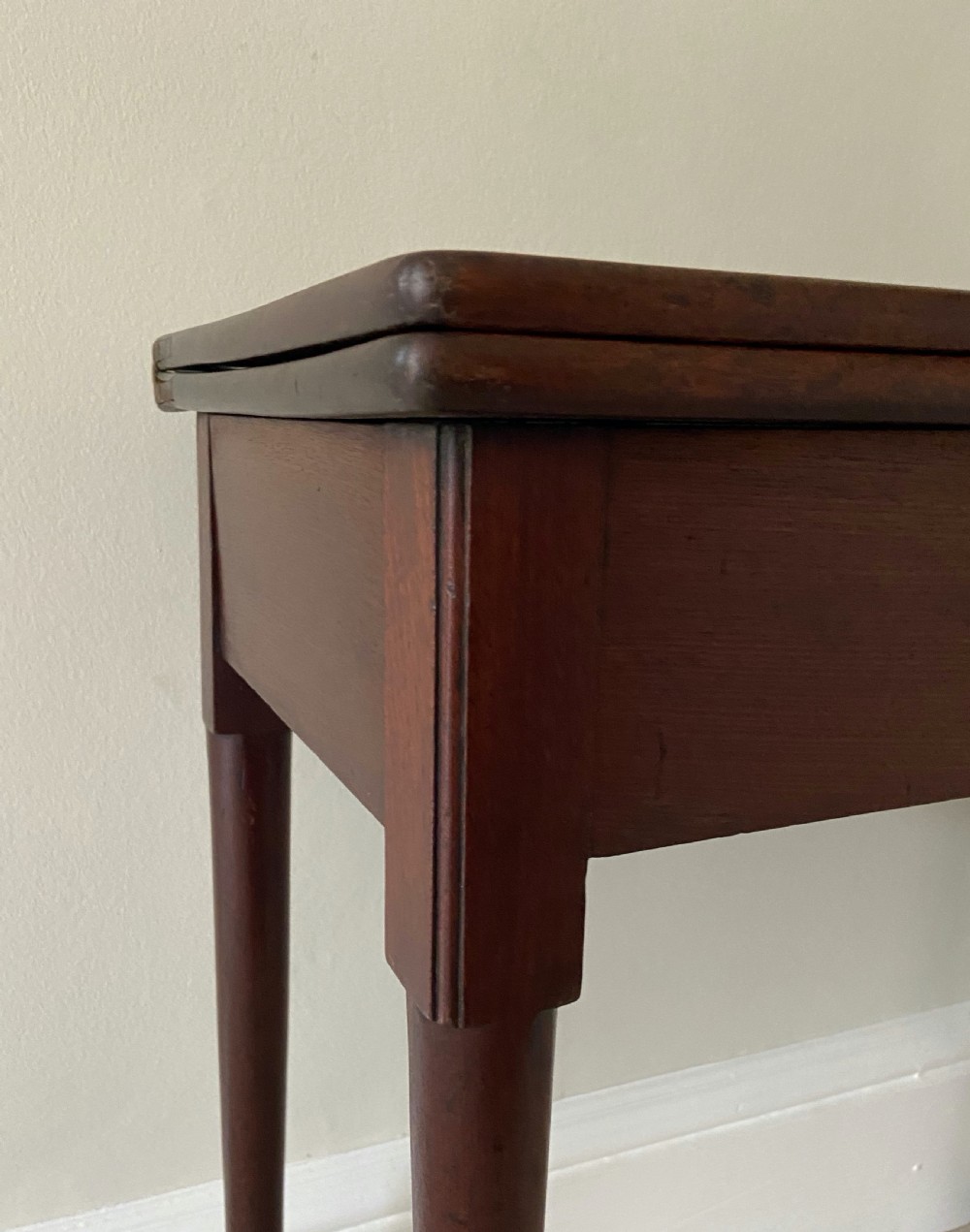 A George II dark walnut fold-over tea table featuring slender cabriole legs terminating in pad feet. View III