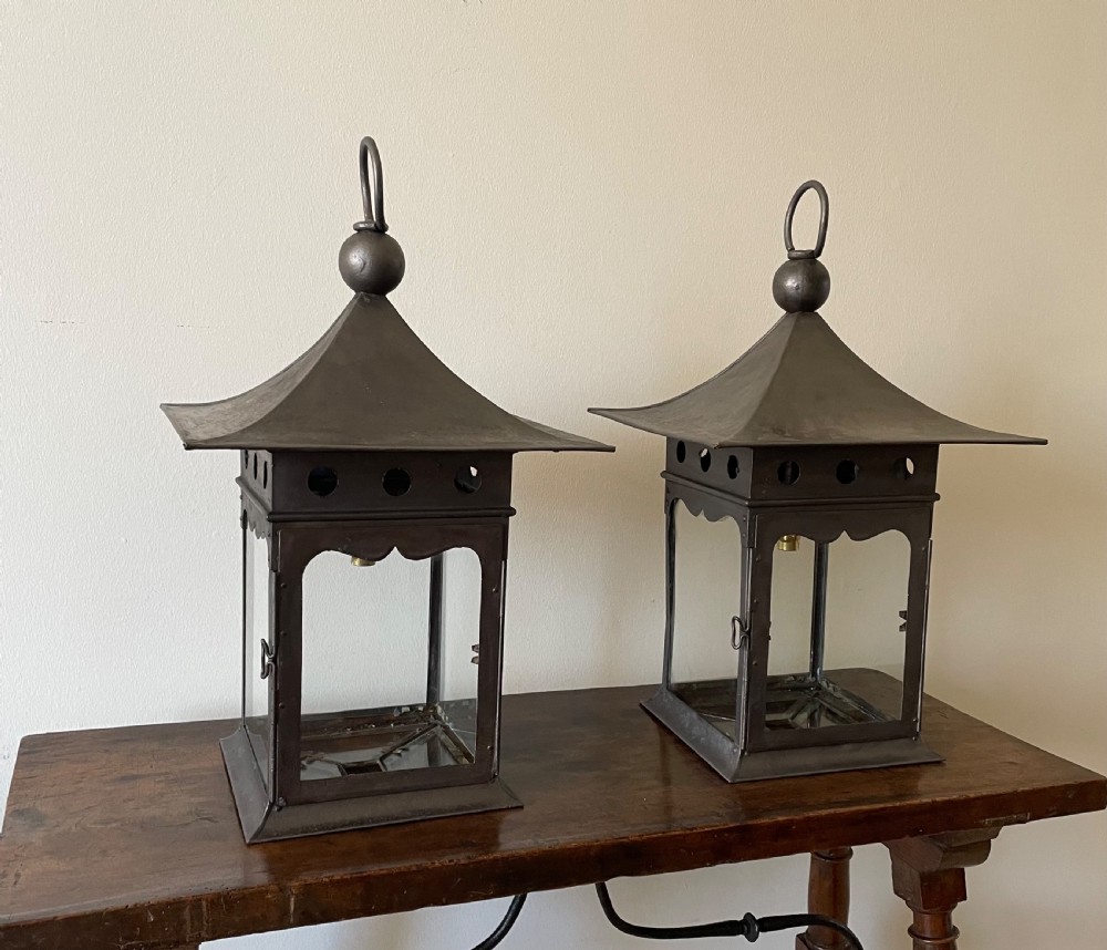 A pair of patinated dark iron Arts and Crafts lanterns featuring pagoda-style roofs, loop finials, circular pierced vents, and clear glass panels. View II