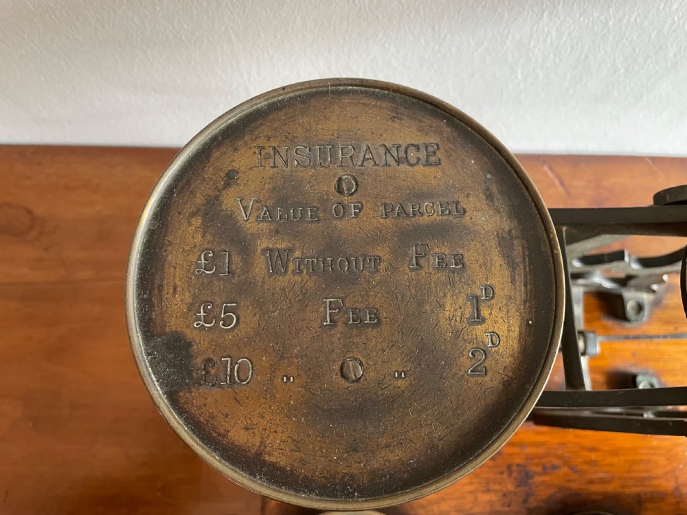 A set of Victorian brass postal scales mounted on a rectangular wooden base with nested brass weights stored in custom cutouts. View III