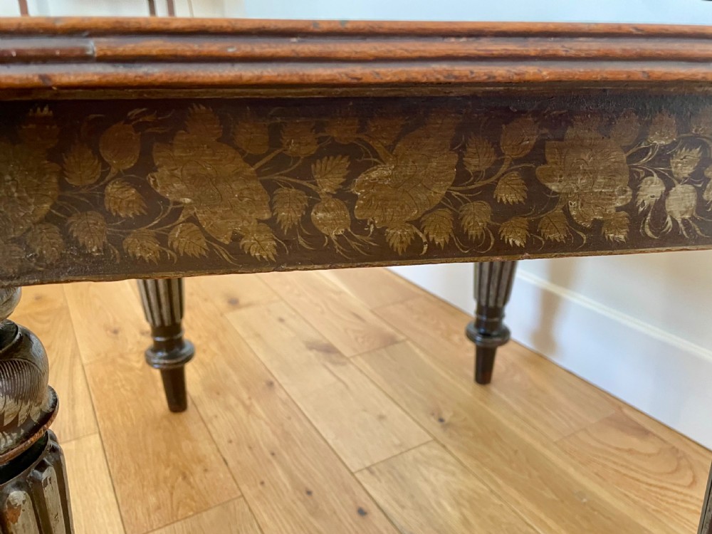 A square dark wood Anglo-Indian side table featuring carved floral friezes and bold fluted turned legs. View II