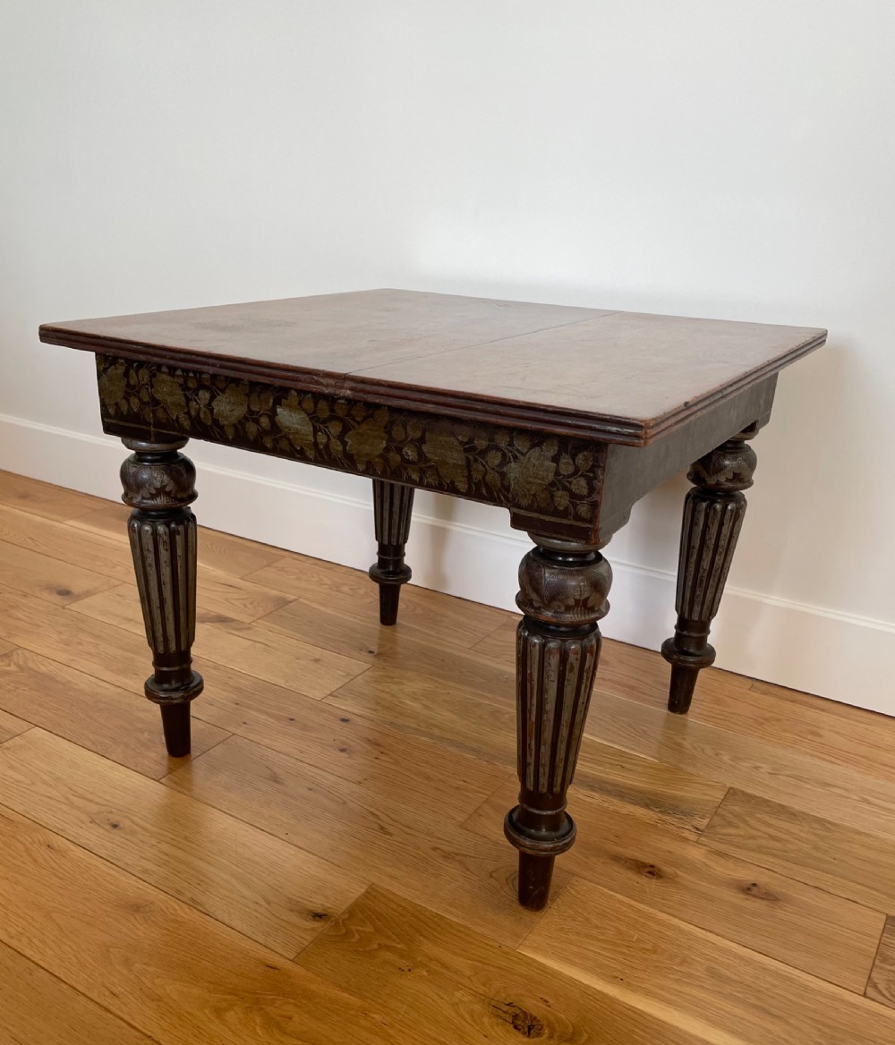 A square dark wood Anglo-Indian side table featuring carved floral friezes and bold fluted turned legs. View V