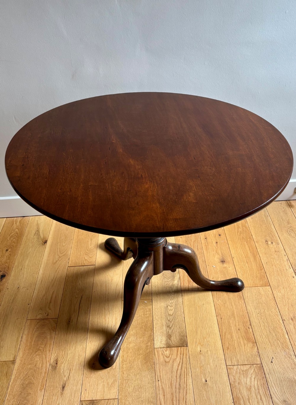 A circular Scottish George II mahogany occasional table featuring a single-piece turned pedestal column set on three cabriole legs with pad feet.