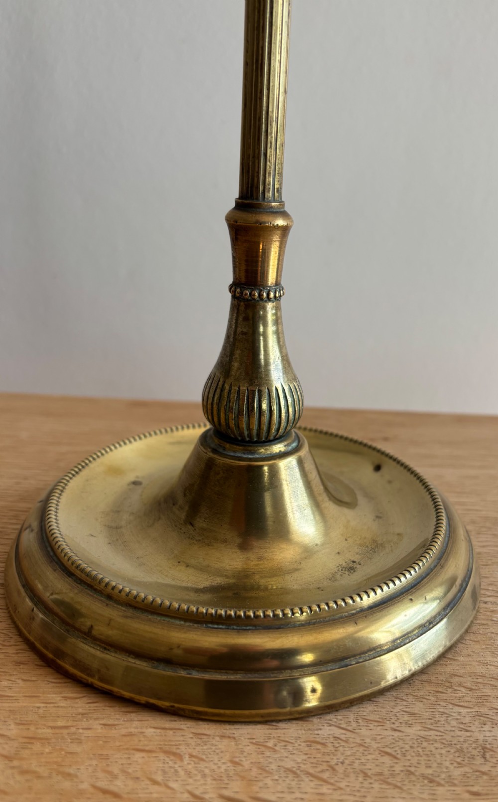 An Edwardian adjustable brass desk lamp featuring a circular stepped base, a vertical pole with a ring finial, a curved arm, and a translucent frilled glass shade. View VI