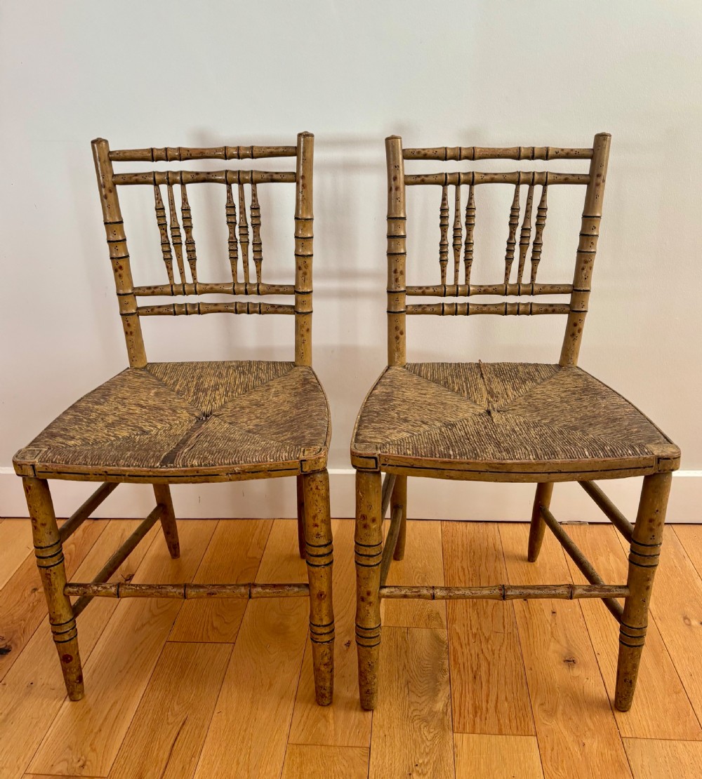 A pair of Regency-style side chairs with painted faux-bamboo wooden frames and woven rush seats.