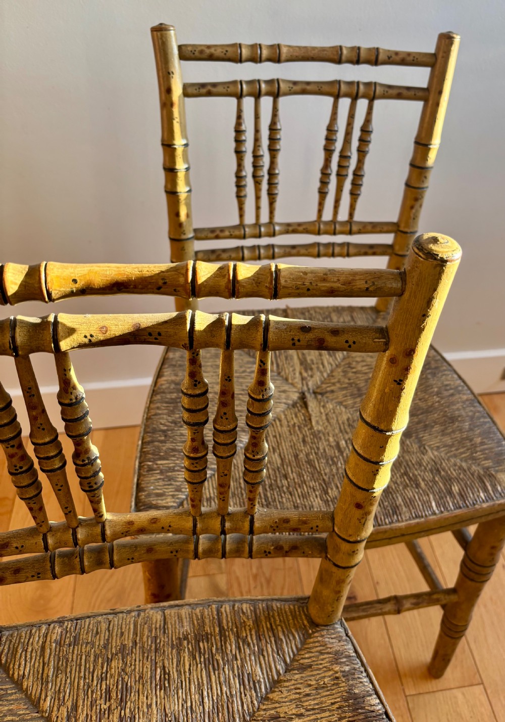 A pair of Regency-style side chairs with painted faux-bamboo wooden frames and woven rush seats. View IV