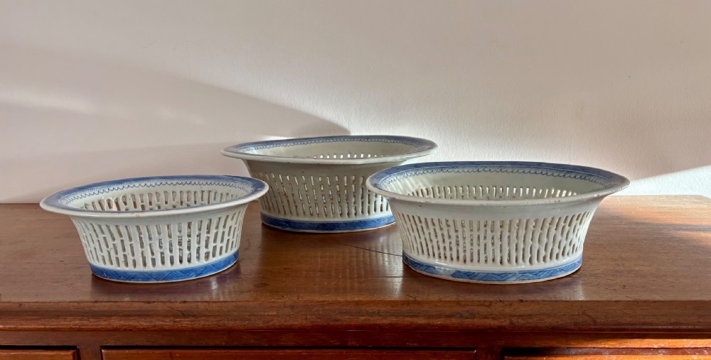 A set of three Chinese export blue and white porcelain reticulated baskets resting on matching pierced undertrays with hand-painted river landscape scenes. View III