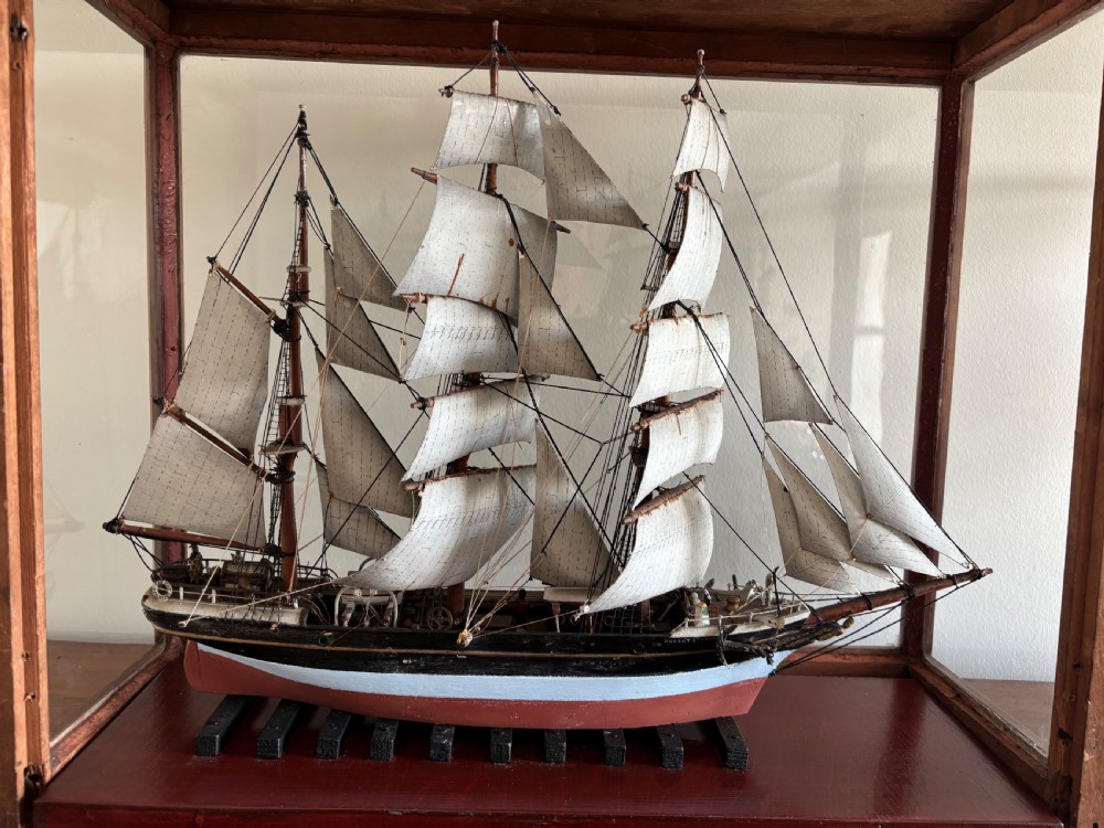 A detailed late Edwardian cased scale model of a three-masted barque sailing ship with full rigging, sails, and a painted hull. View II