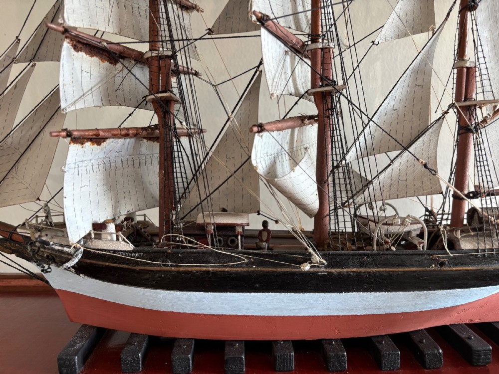 A detailed late Edwardian cased scale model of a three-masted barque sailing ship with full rigging, sails, and a painted hull. View V