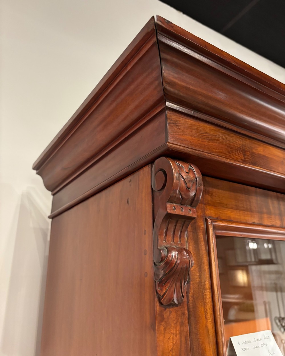 A large Mid-Victorian mahogany bookcase featuring four glazed doors, carved corbels at the upper corners, and adjustable internal shelving. View III
