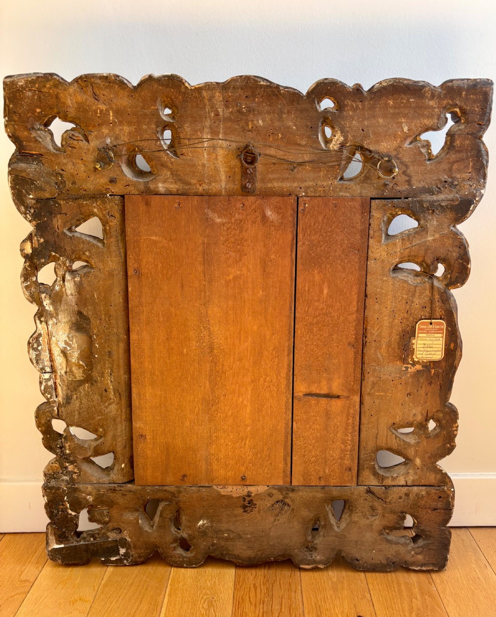 A rectangular mirror enclosed within a heavily carved giltwood frame featuring elaborate scrollwork and shell motifs. View V