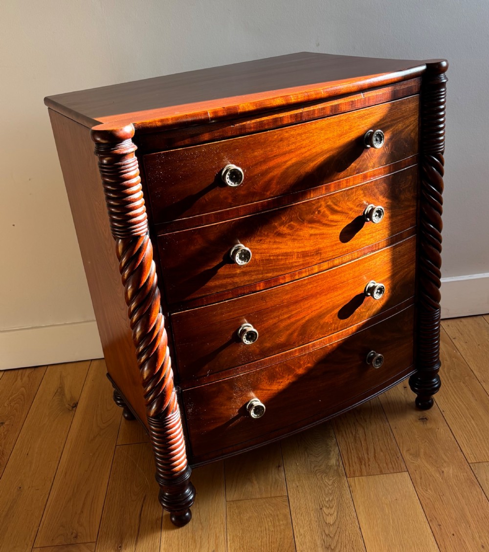 A small William IV mahogany bowfront chest of four drawers flanked by carved spiral-twist side columns and supported on turned feet. View III
