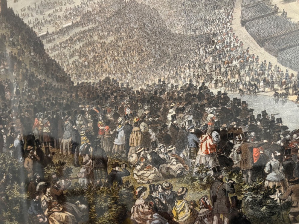 A framed Victorian military print depicting a panoramic view of the Royal Review of the Scottish Volunteers in a dark wooden frame with a gold slip. View II