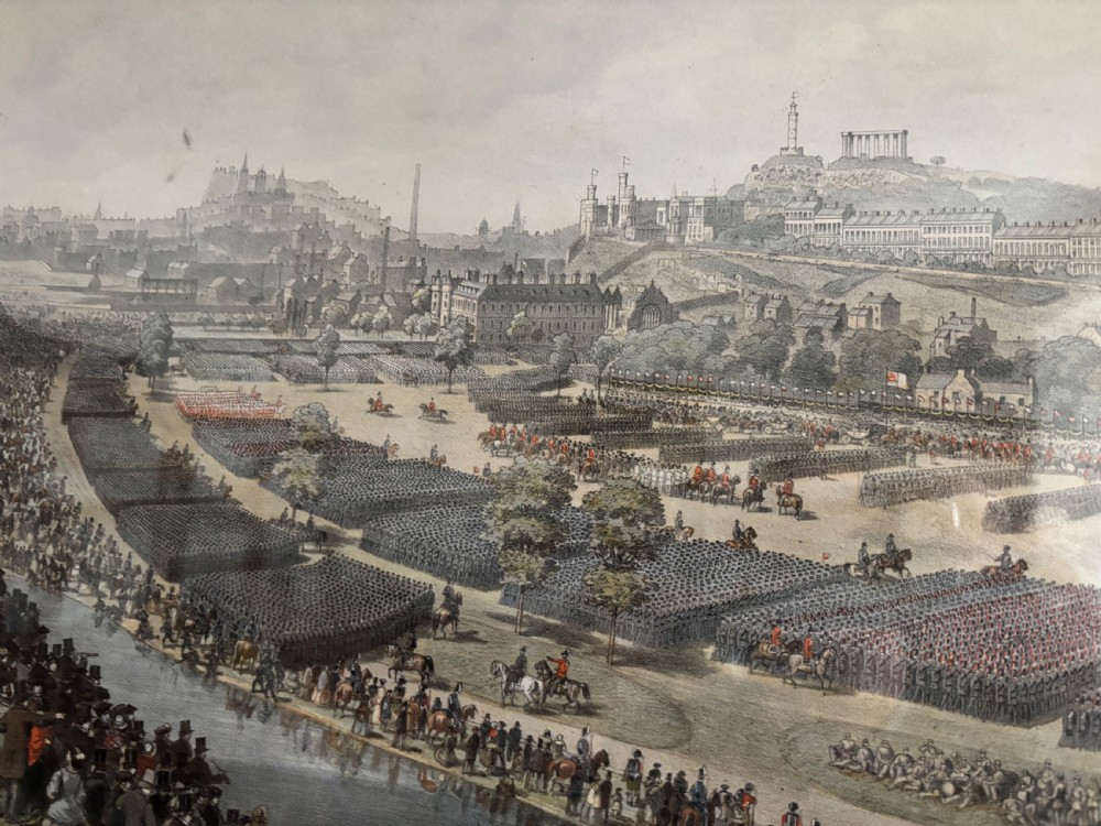 A framed Victorian military print depicting a panoramic view of the Royal Review of the Scottish Volunteers in a dark wooden frame with a gold slip. View V