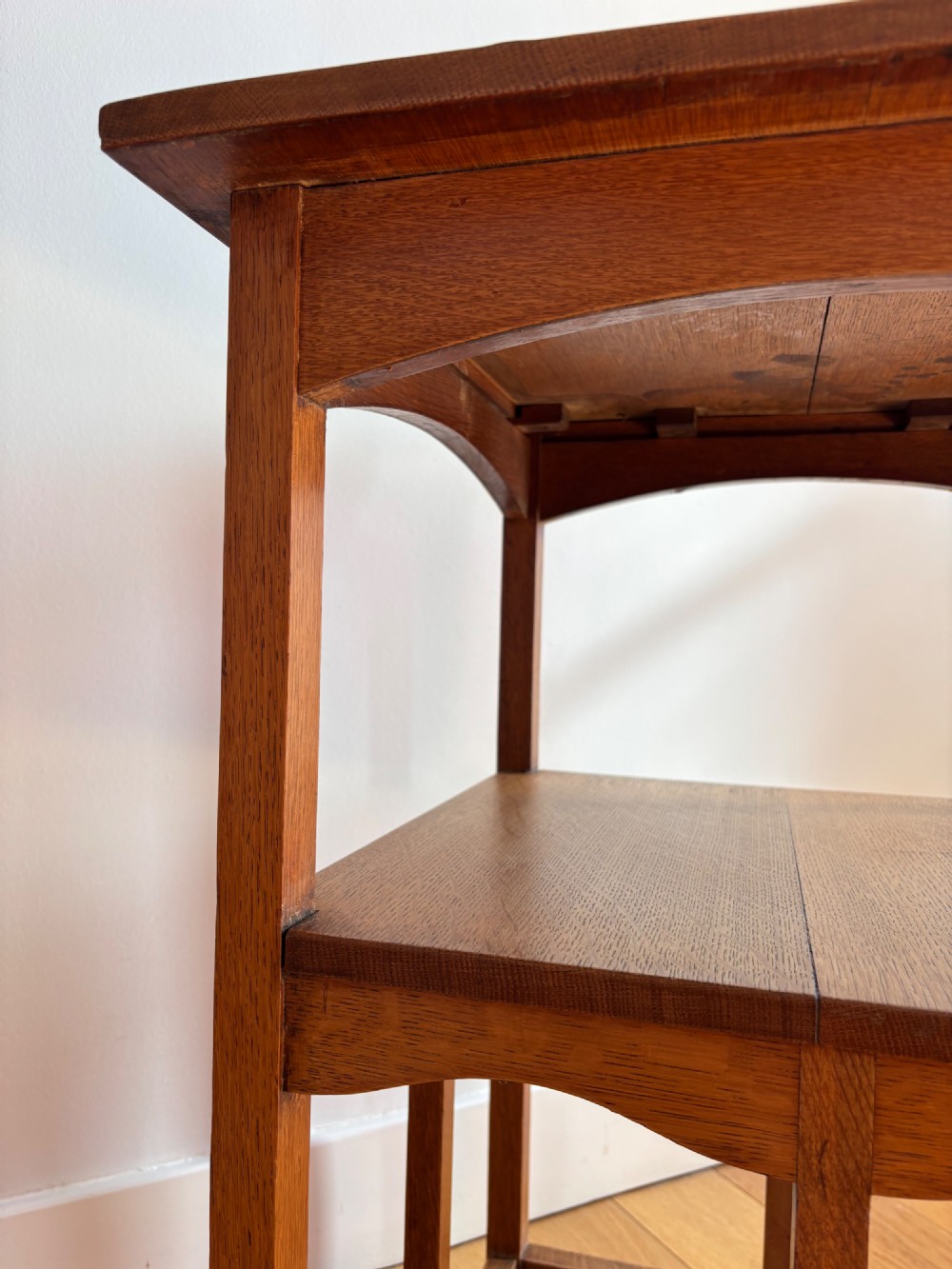 An antique Arts and Crafts square oak occasional table featuring a central marquetry motif, banded inlay border, lower tier shelf, and straight legs. View VI