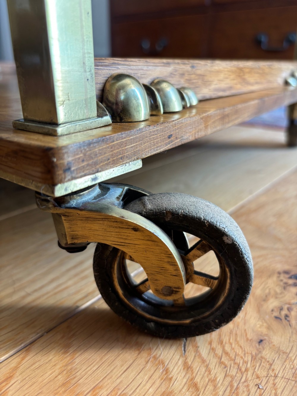 A late Victorian three-tier oak and brass etagere trolley with vertical brass supports and metal castors. View VI