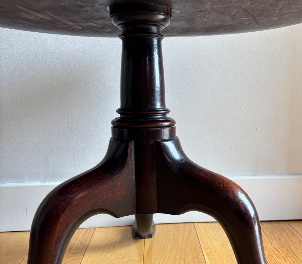 An early George III mahogany dumb waiter featuring three graduated circular trays on a turned central column supported by a tripod base with pad feet. View II