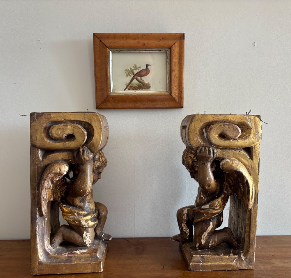 A pair of 19th-century carved giltwood wall brackets featuring winged cherub figures supporting scrolled capitals. View III