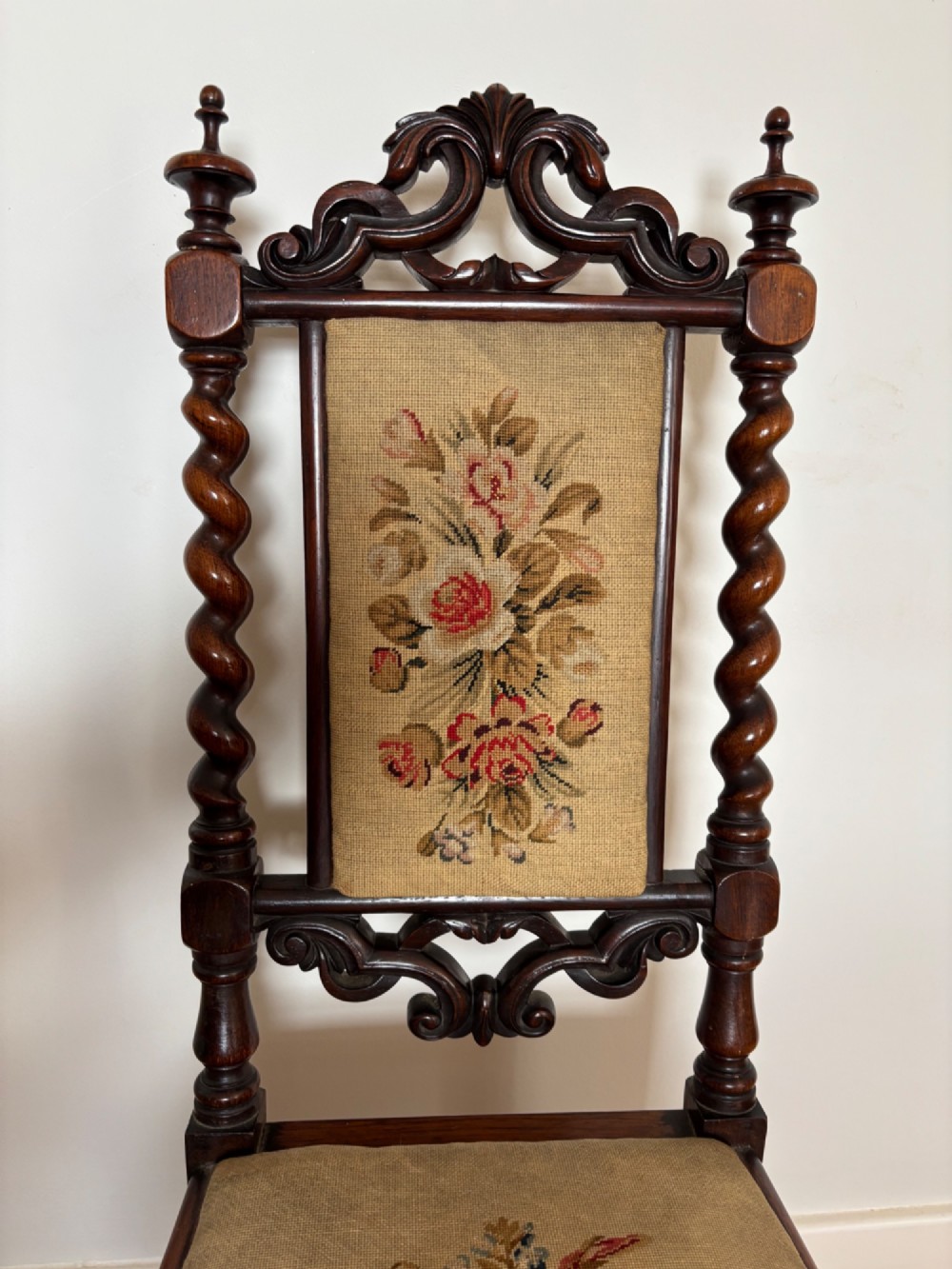 A Victorian rosewood childs chair with barley twist uprights, floral scrollwork carvings, and floral needlepoint upholstery on the seat and backrest. View II