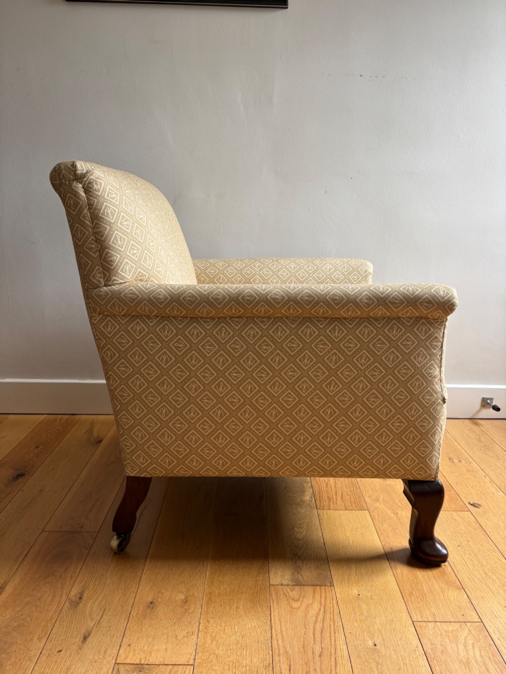 A pair of fully upholstered low-back armchairs with patterned beige fabric and dark mahogany cabriole legs. View V