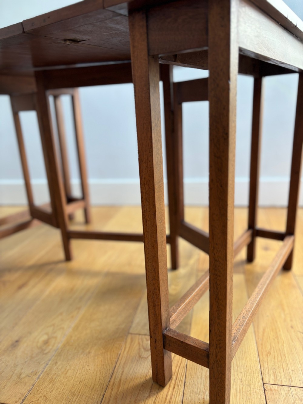 A rectangular mahogany folding table with visible brass hinges and a foldable timber leg support structure. View VI